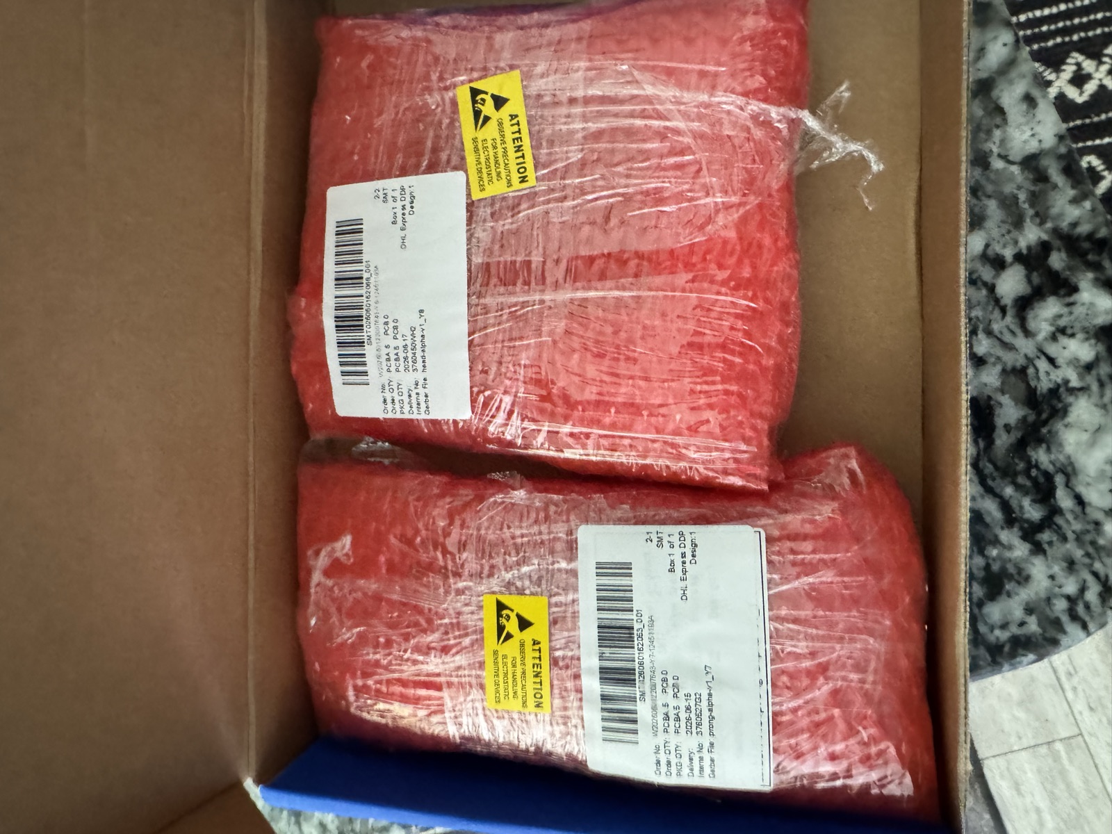 Two anti-static bagged batches of PCBs inside the opened shipping box