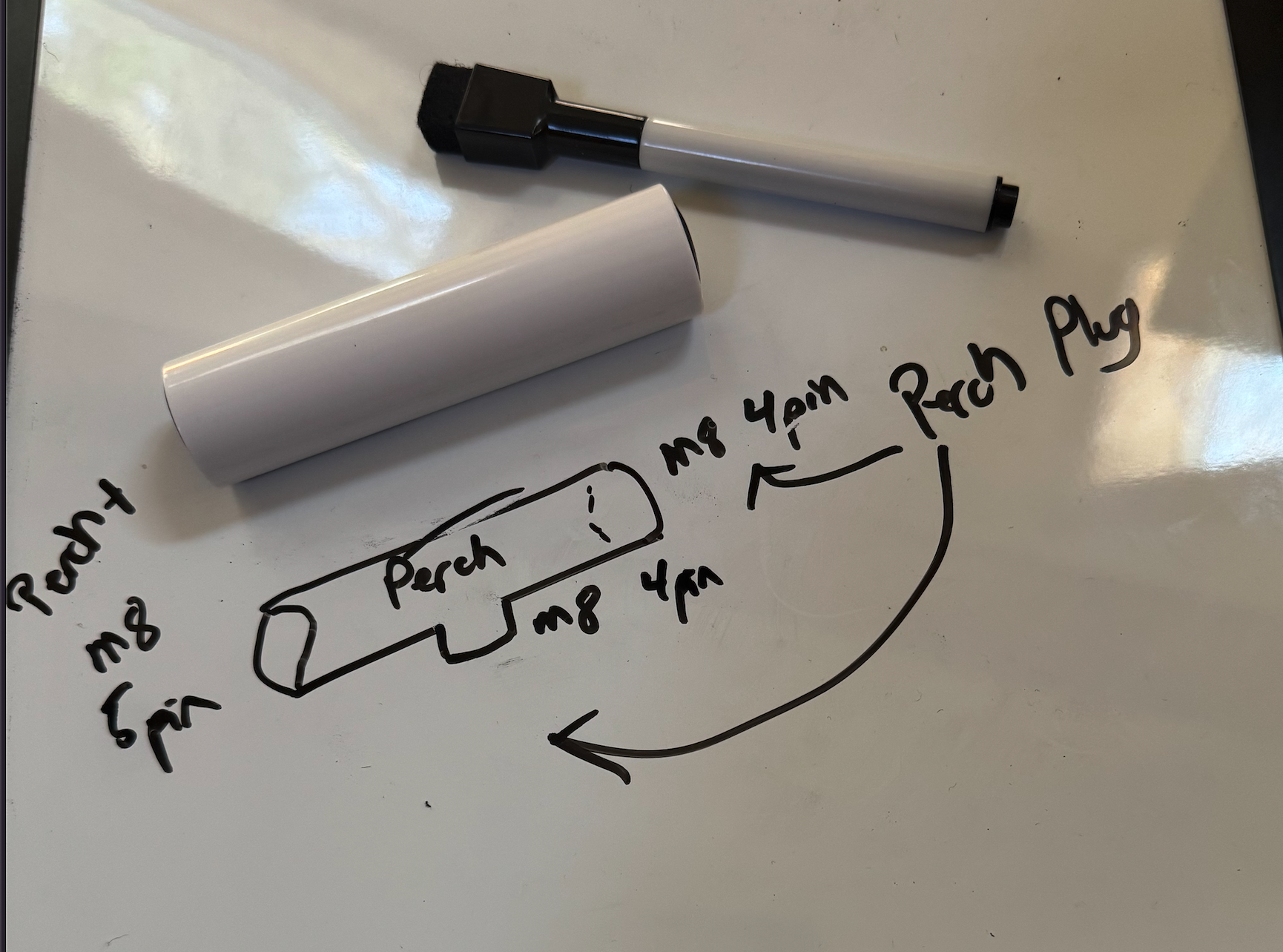 Whiteboard sketch of the Phoebe bird body showing M8 Perch ports, with an 18650 battery next to it for scale